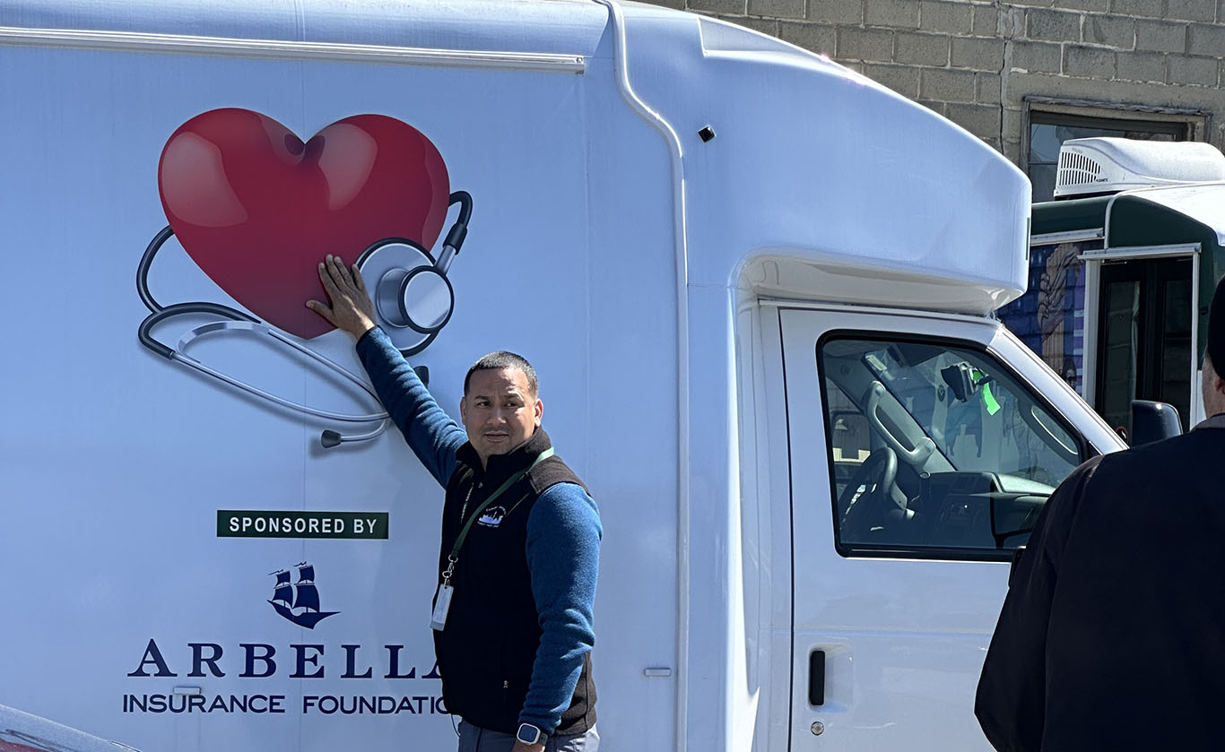 Ben Gonzalez stands in front of the Mobile Health Clinic he drives for GLFHC as part of the Health Care for the Homeless Program.